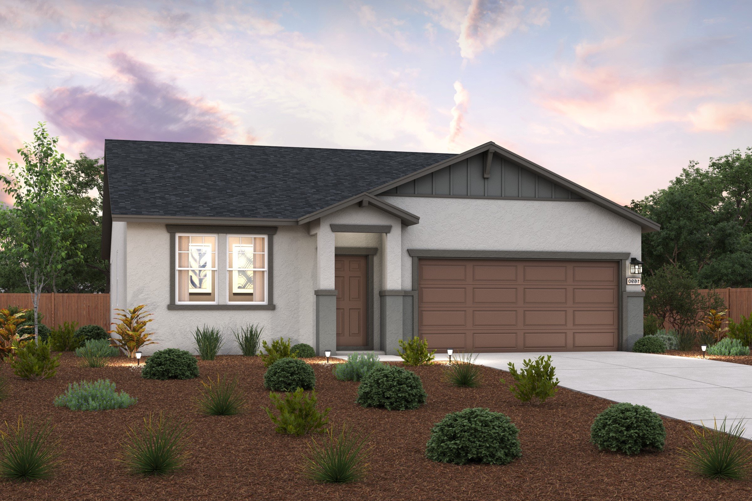 A house with a garage and bushes in front of it.