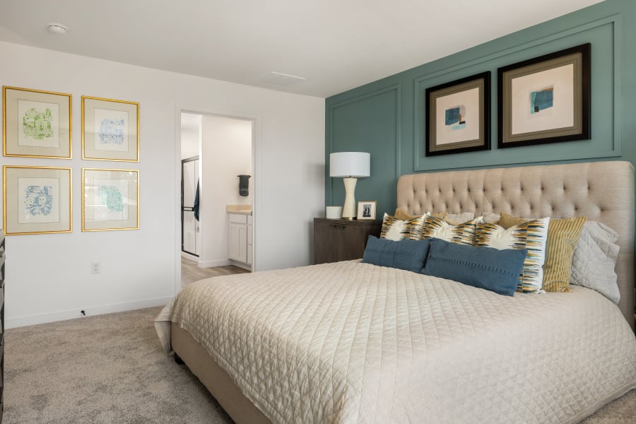 A bedroom with a bed and a lamp.