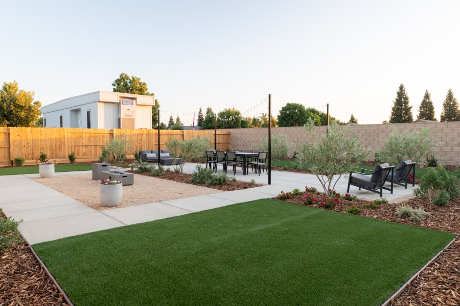A backyard with a brick wall and a brick fence.
