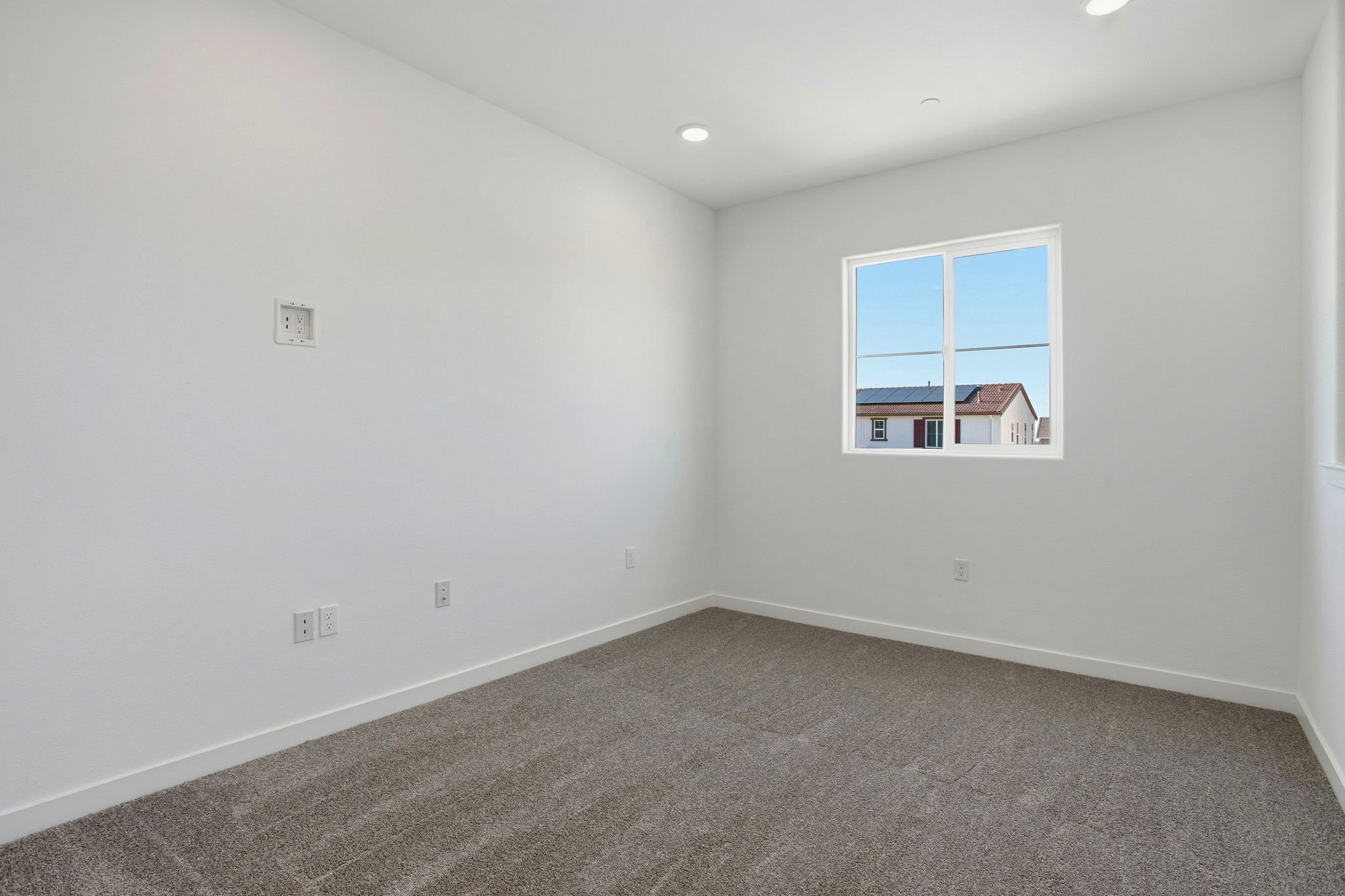 A room with a window and carpet.