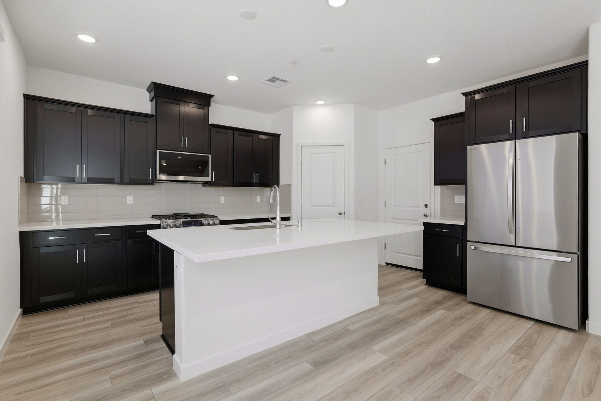 A kitchen with black cabinets.
