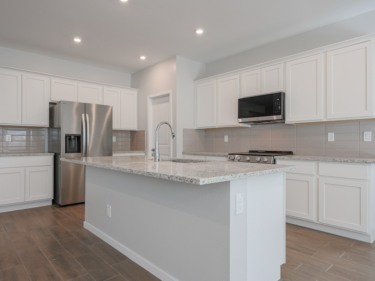 A kitchen with white cabinets.