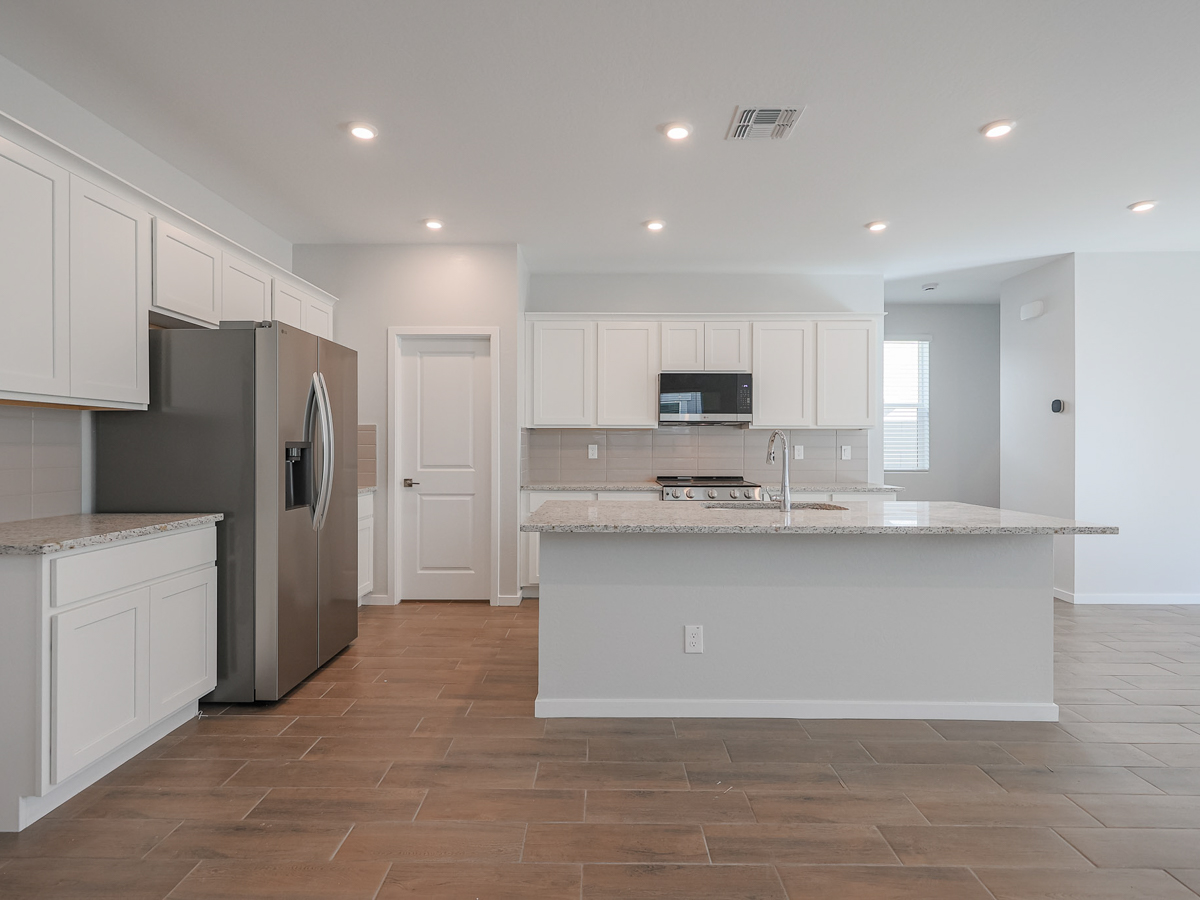 A kitchen with white cabinets.