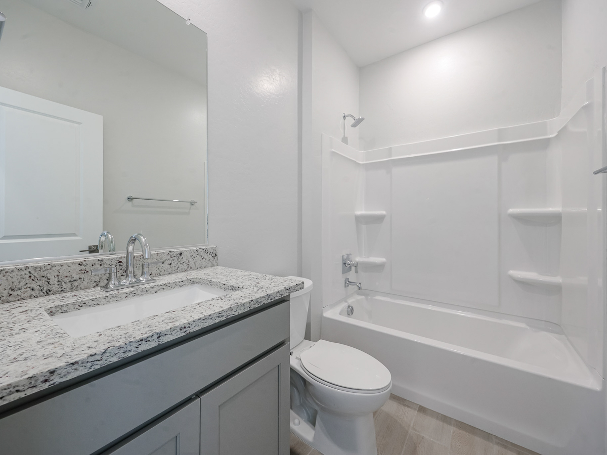 A bathroom with a tub sink and toilet.