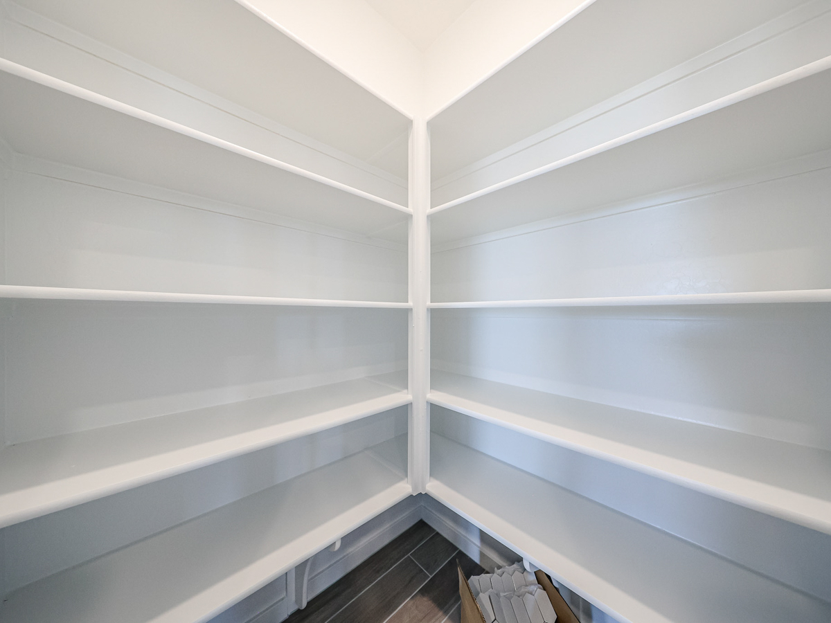 A white shelf with white walls.