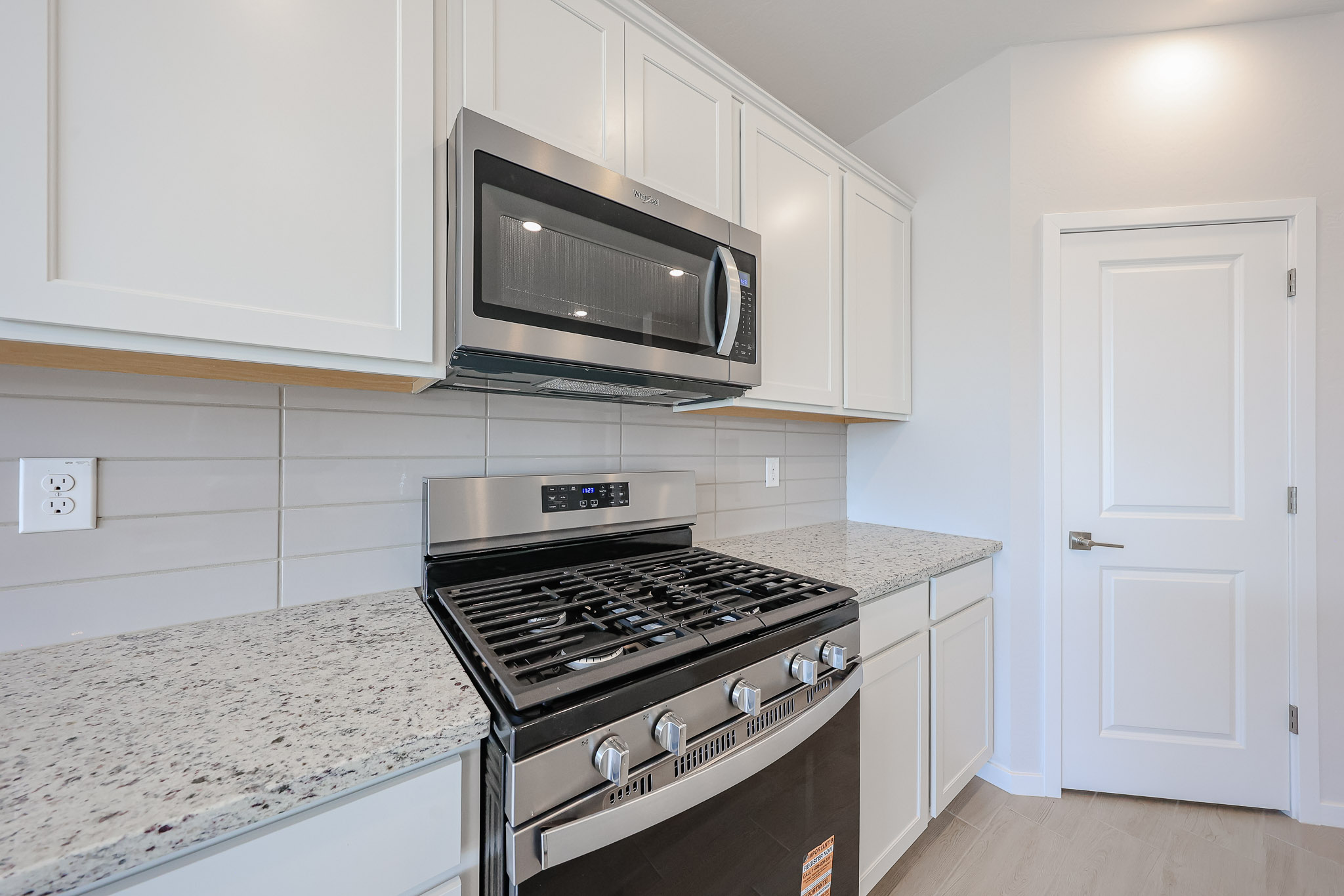 A kitchen with white cabinets.