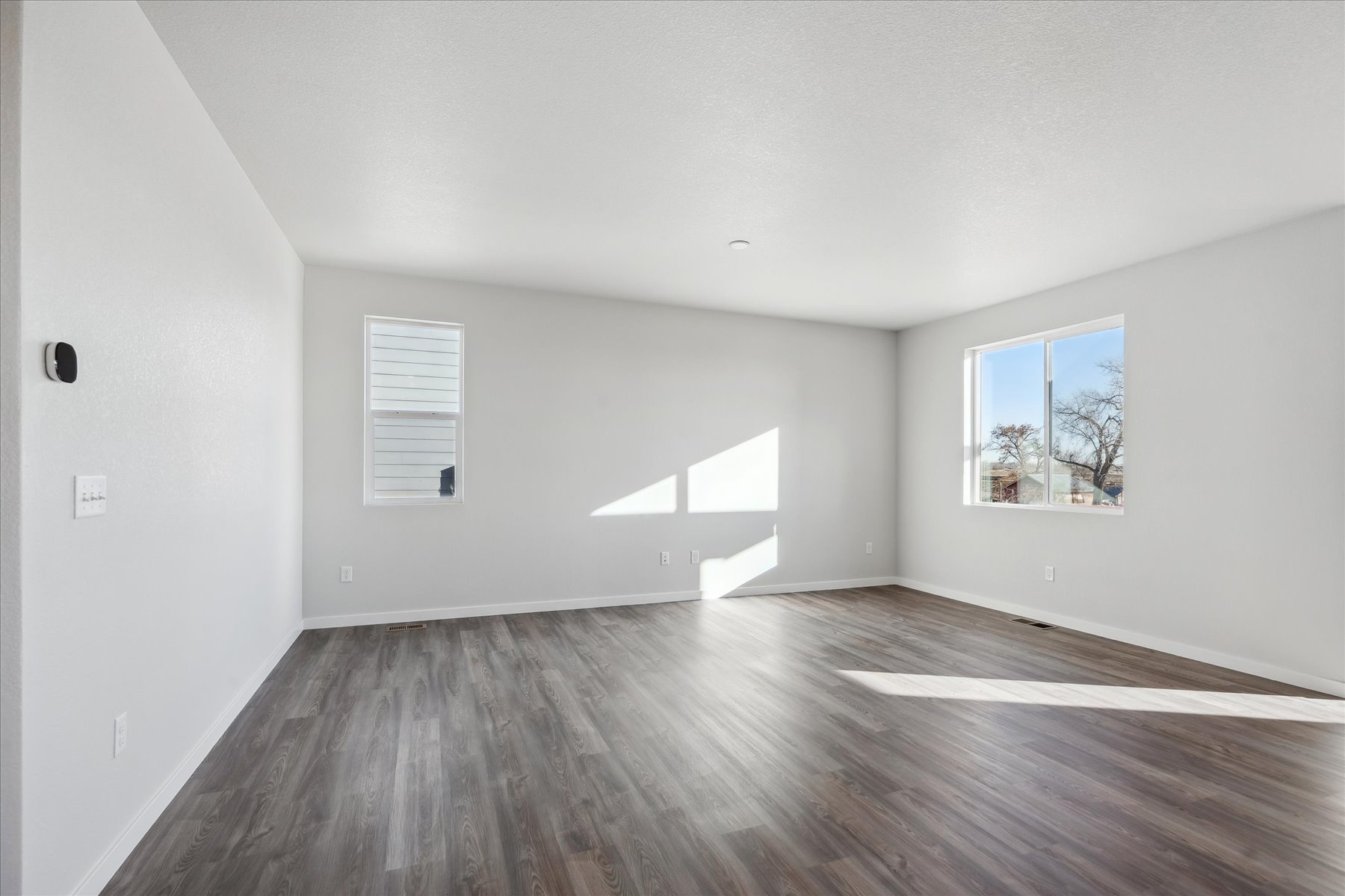 A room with a wood floor and a window.
