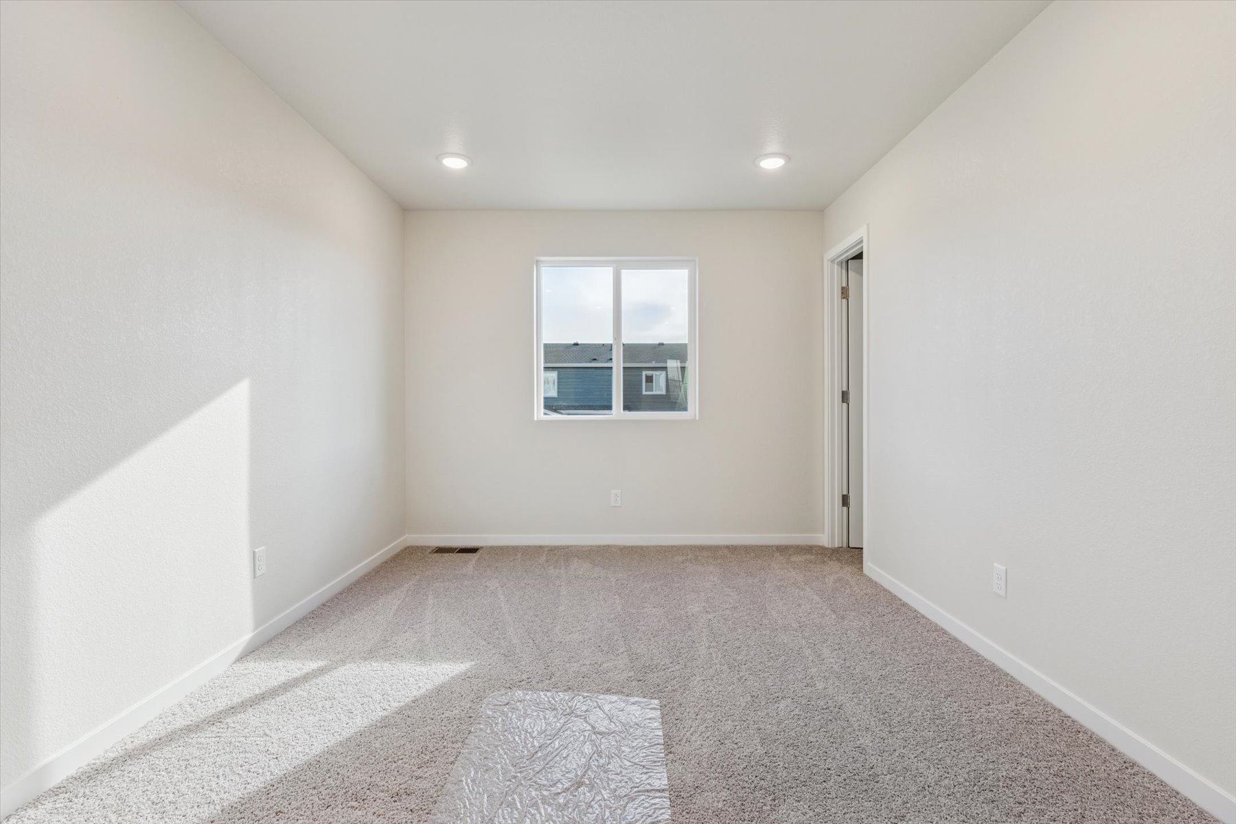 A room with a rug and a window.