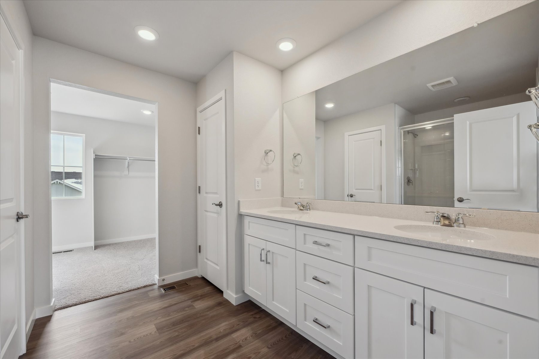 A bathroom with white cabinets.