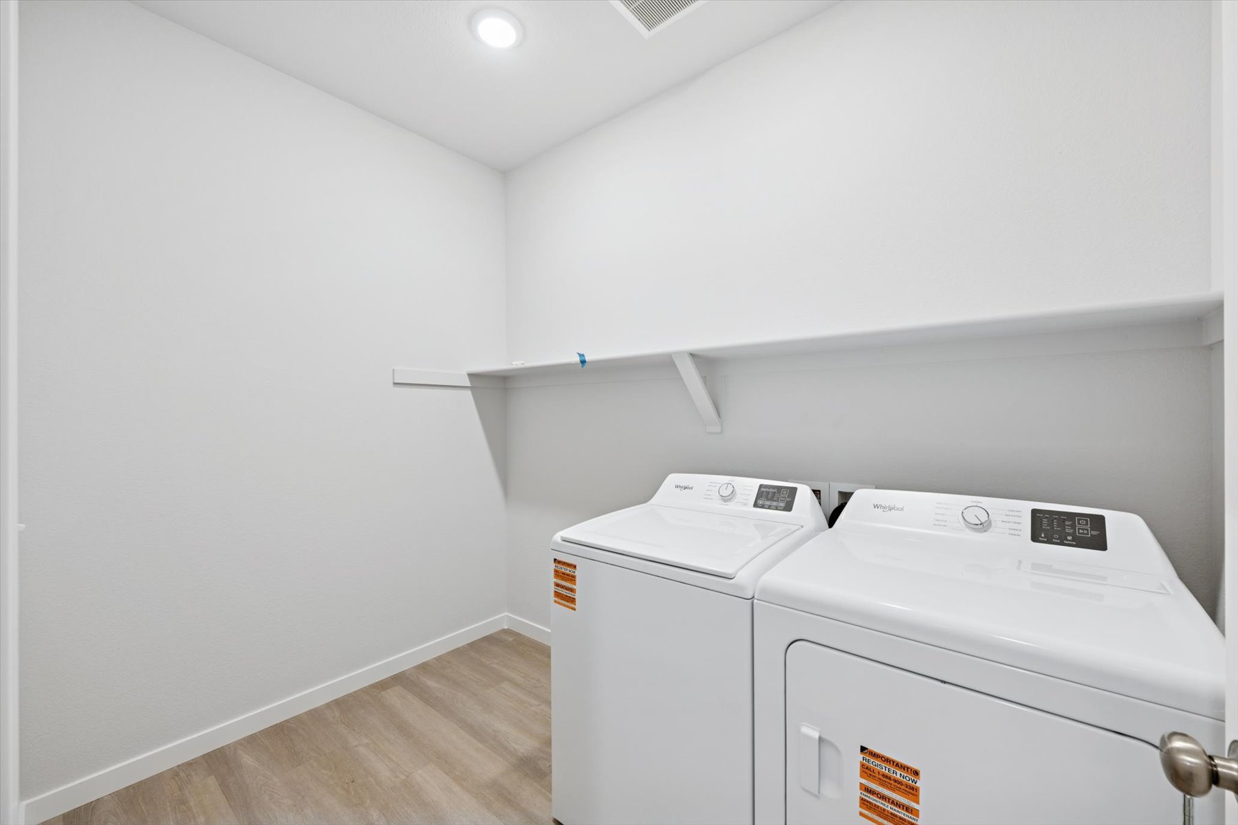 A room with a washing machine and a white wall.
