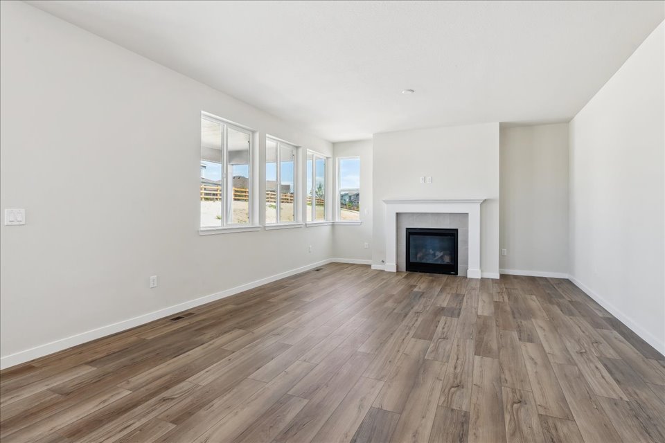 A room with a fireplace and a wood floor.