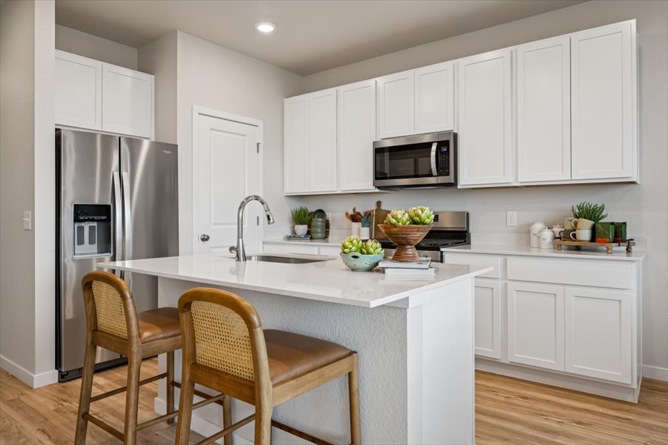 A kitchen with white cabinets.