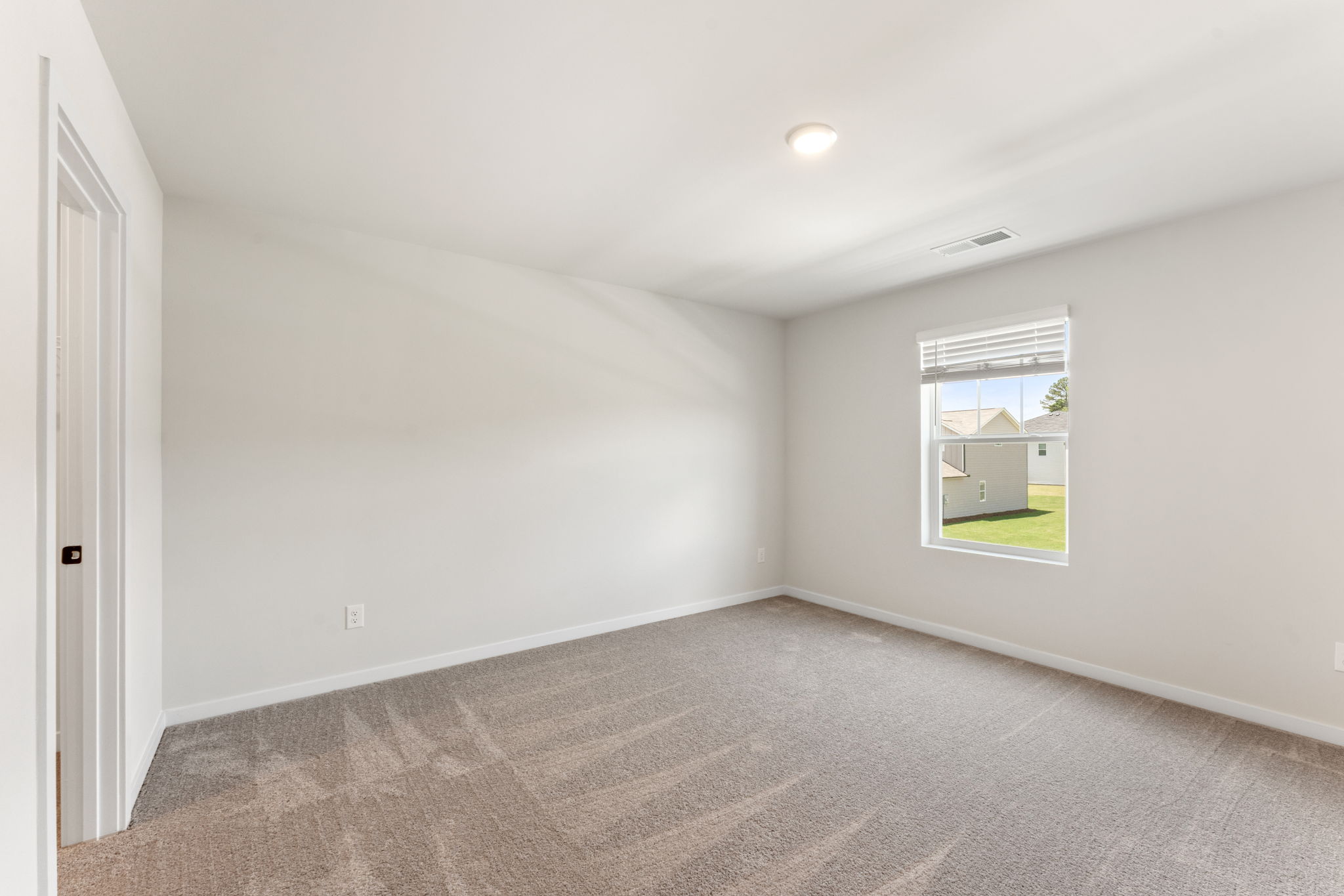 A room with a carpet and a window.