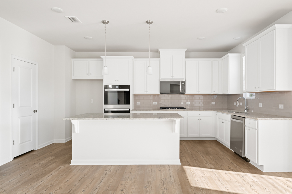 A kitchen with white cabinets.
