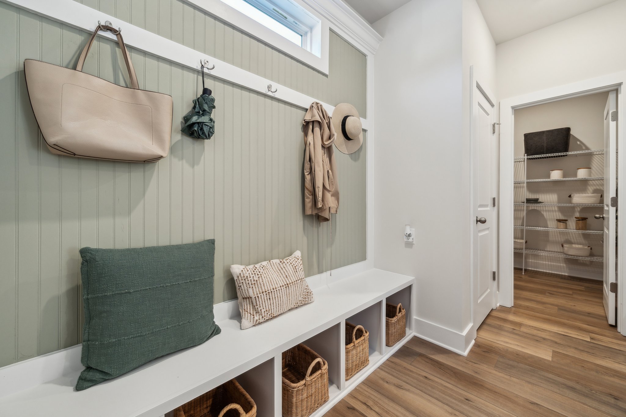 A room with a bed and a shelf with hats on it.