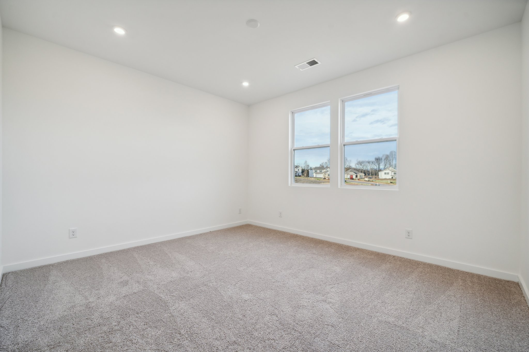 A room with a window and a carpet.