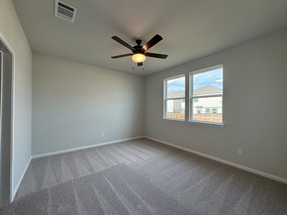 A room with a ceiling fan and a window.