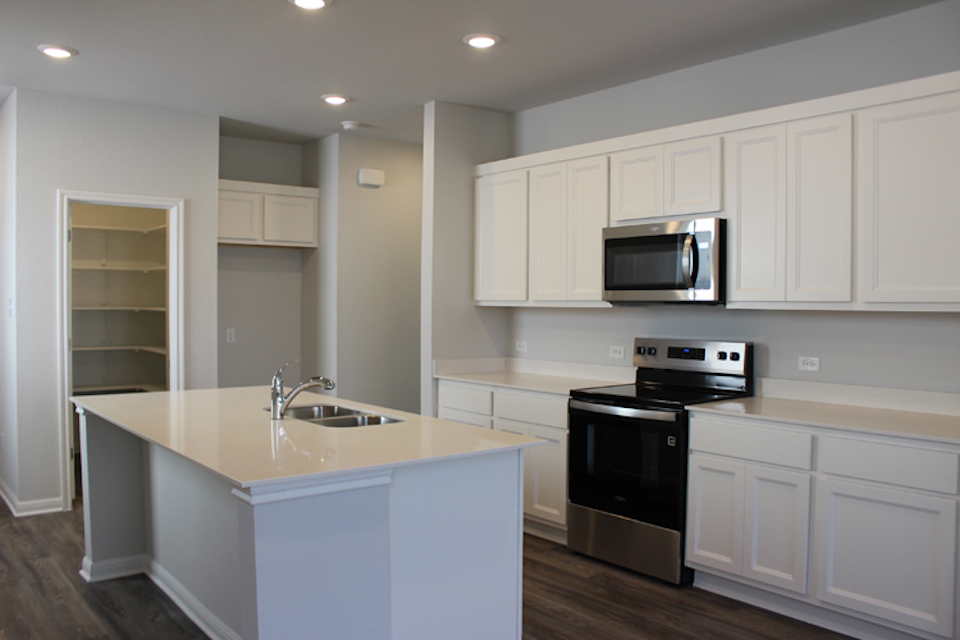 A kitchen with white cabinets.