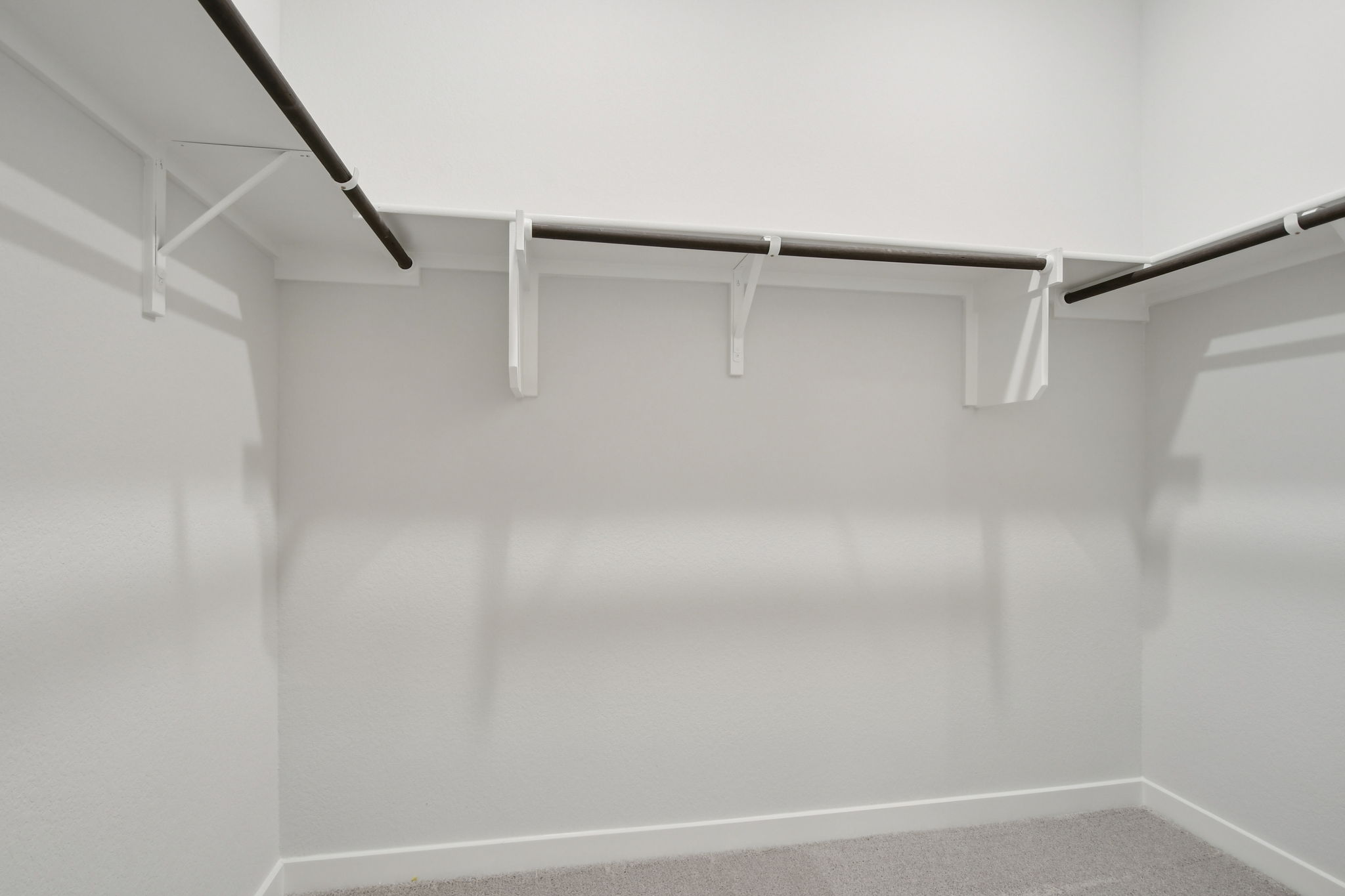 A white wall with a metal bar.