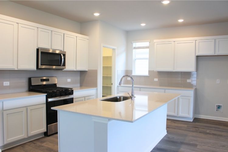 A kitchen with white cabinets.