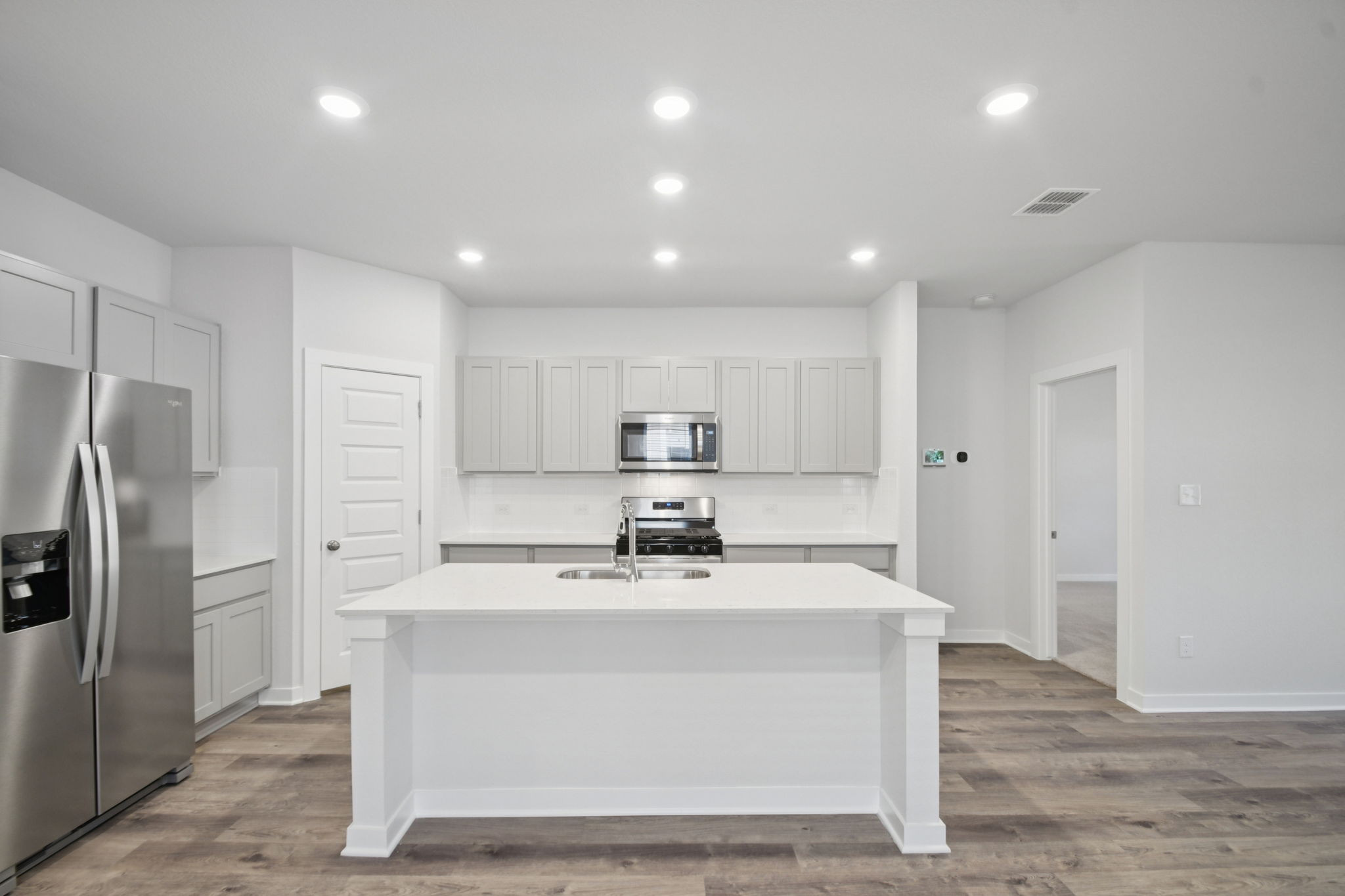A kitchen with white cabinets.