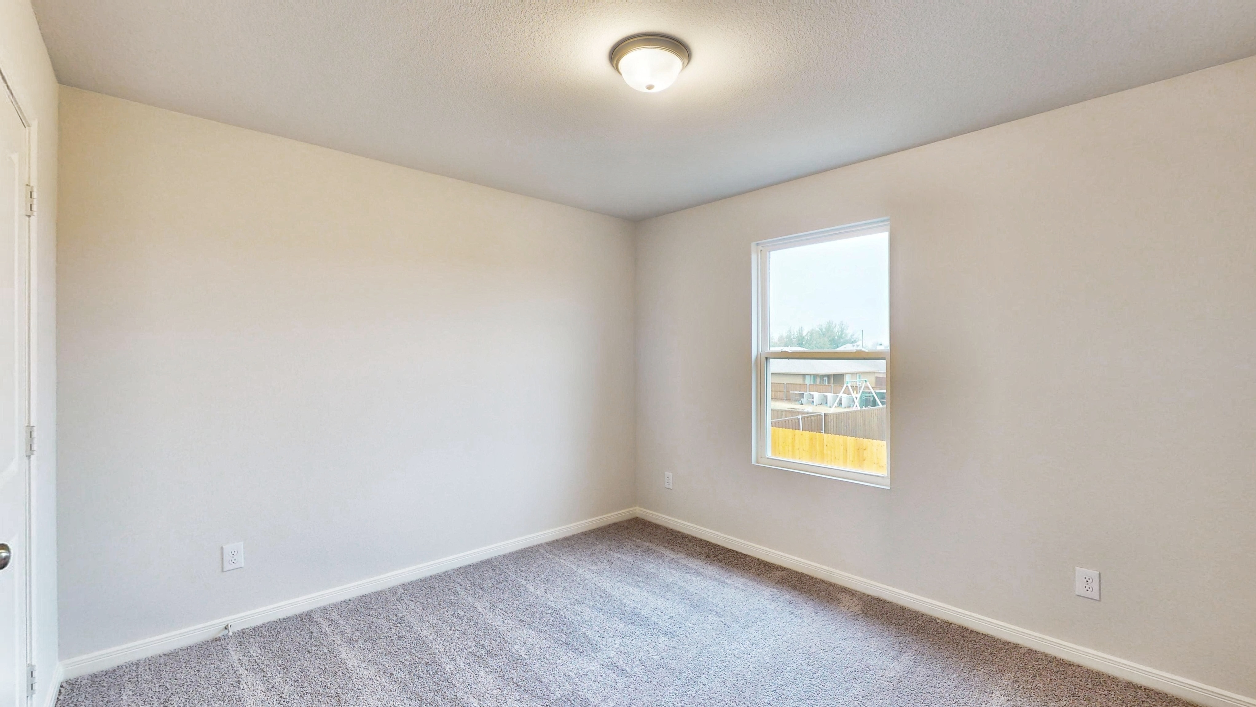A room with a window and a carpet.