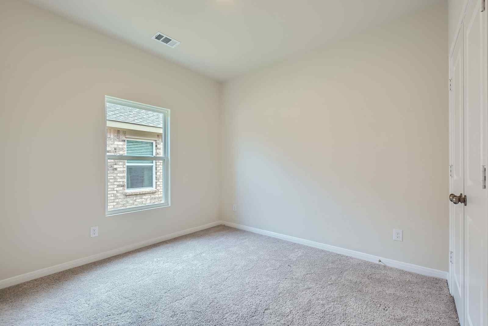 A room with a window and a carpet.