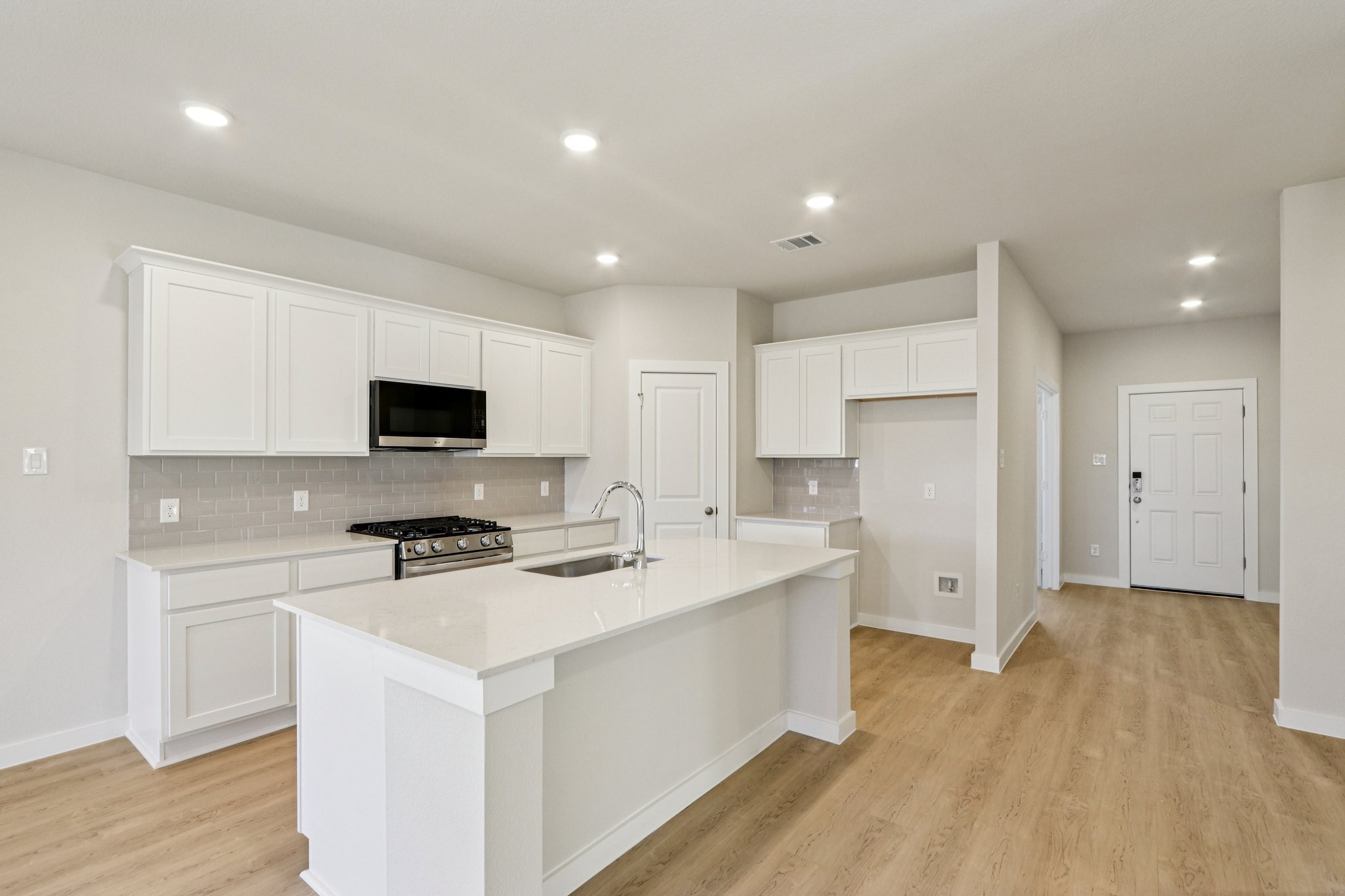 A kitchen with white cabinets.