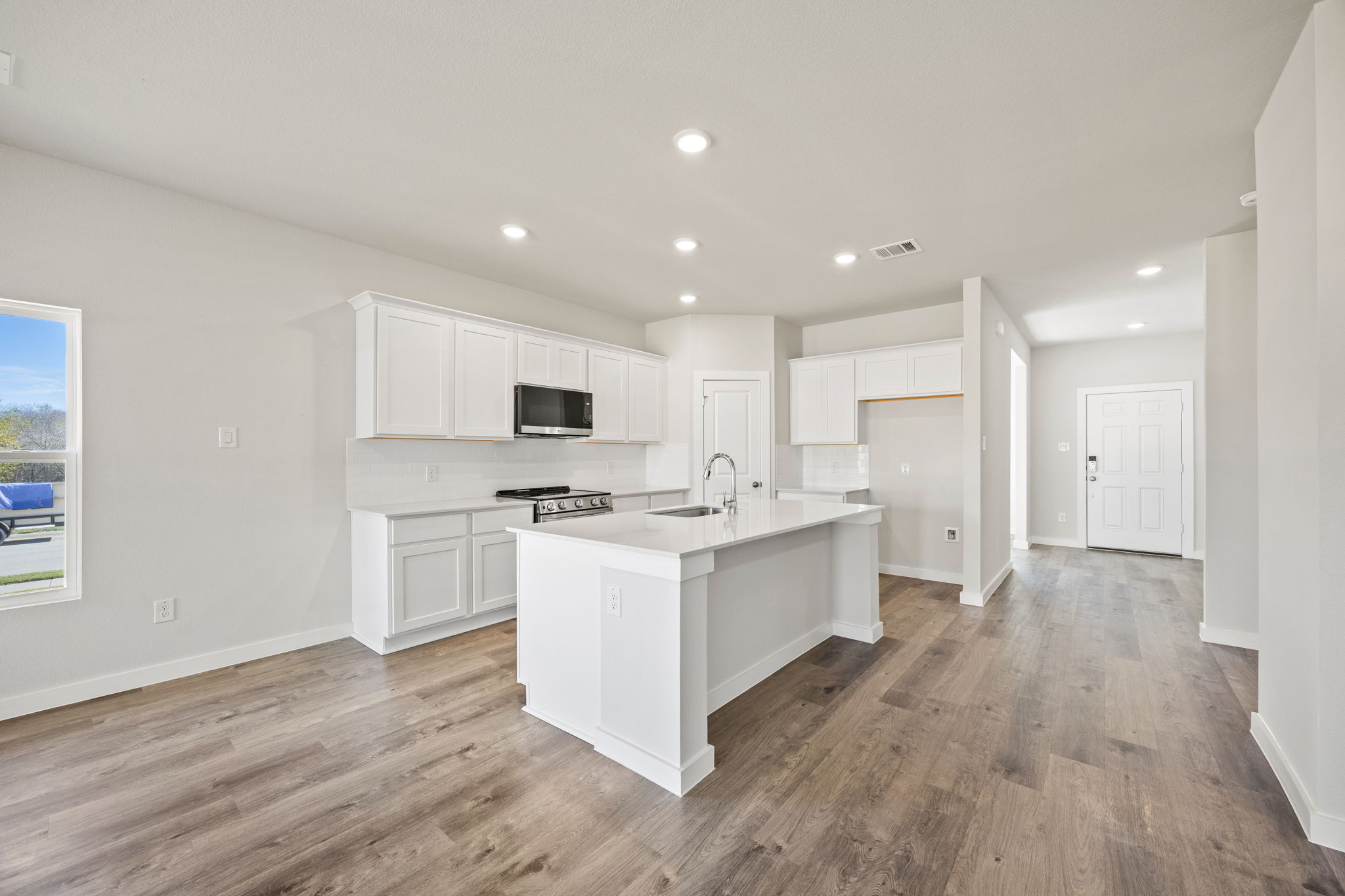 A kitchen with white cabinets.