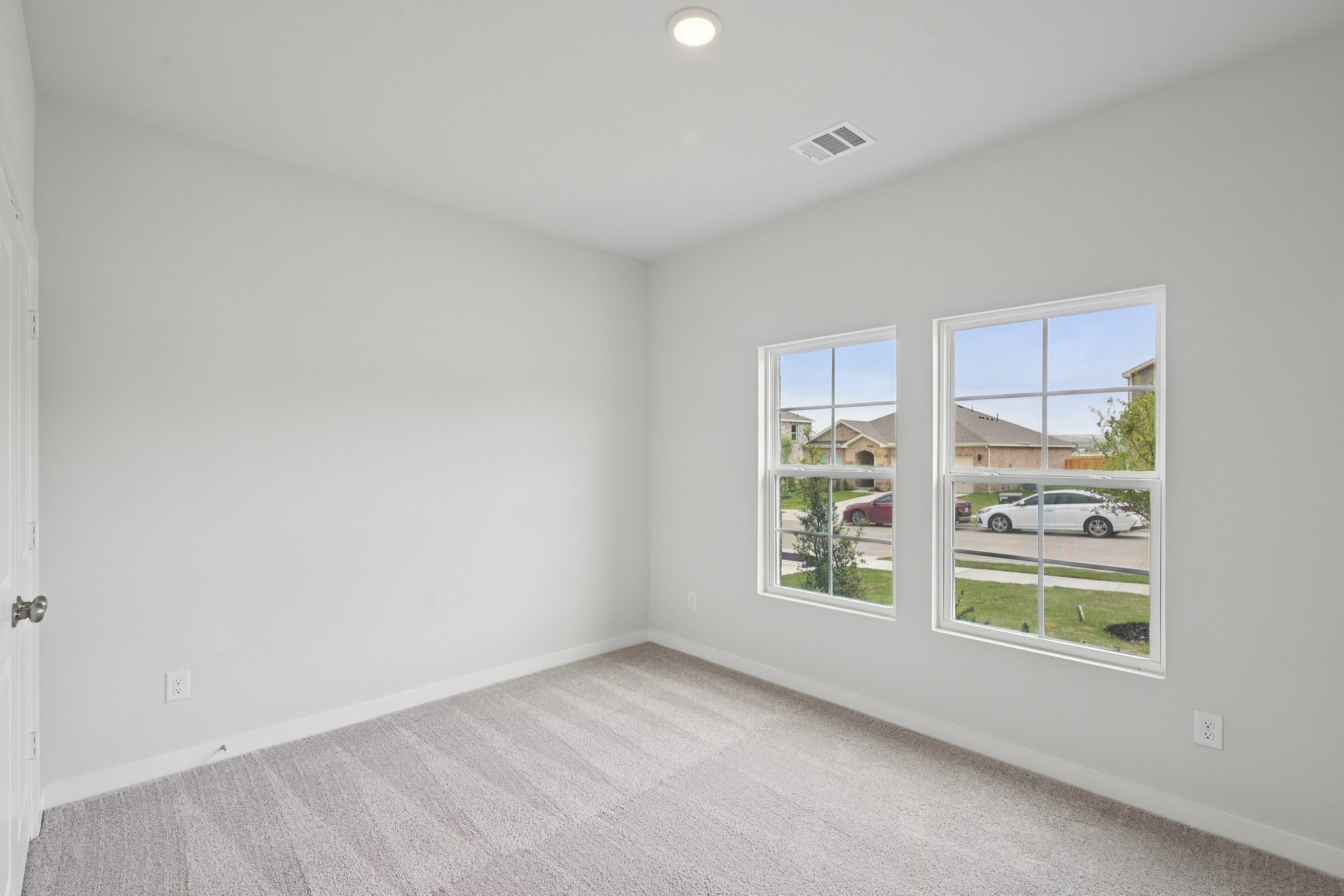 A room with a window and a carpet.