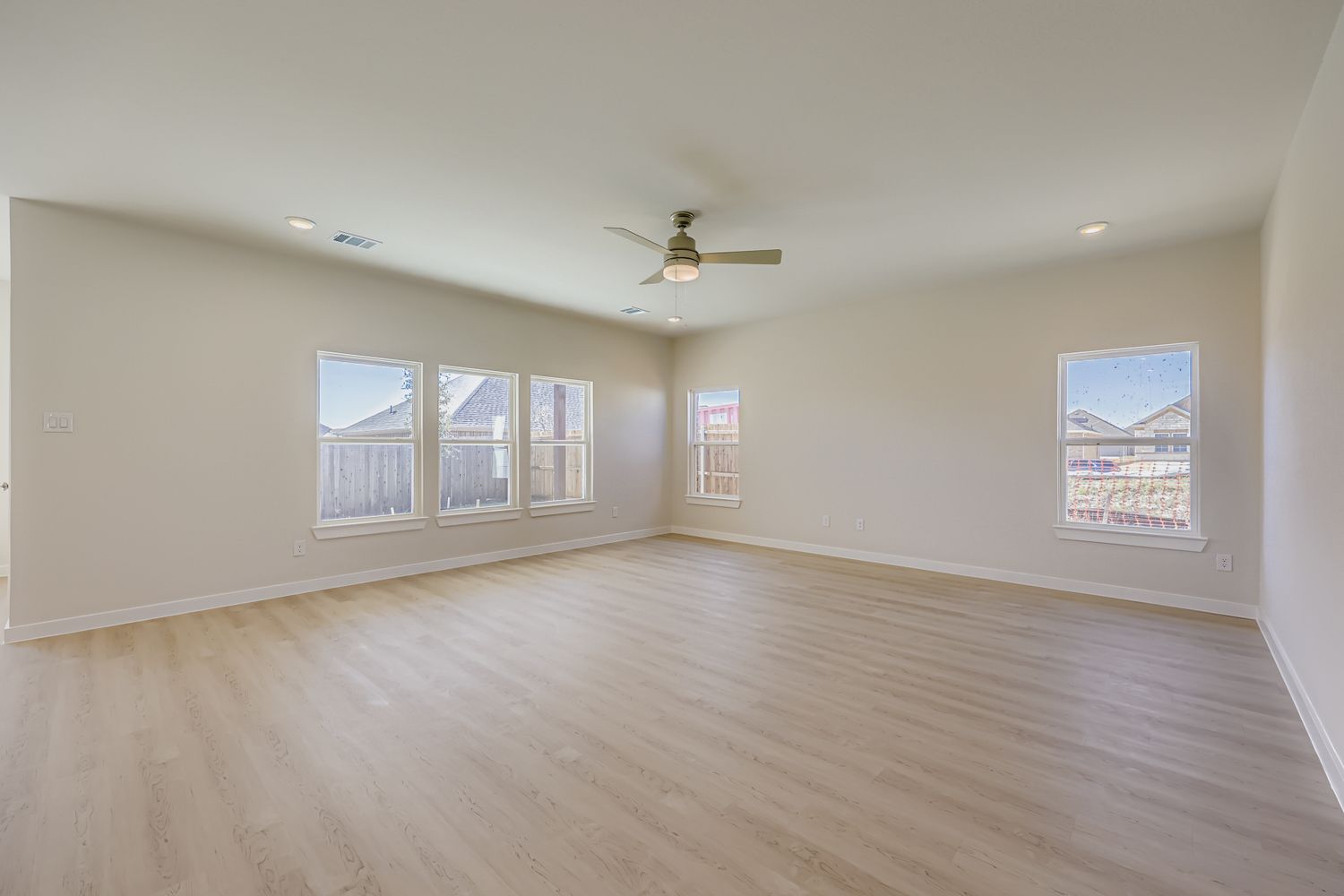 A room with a wood floor and a ceiling fan.