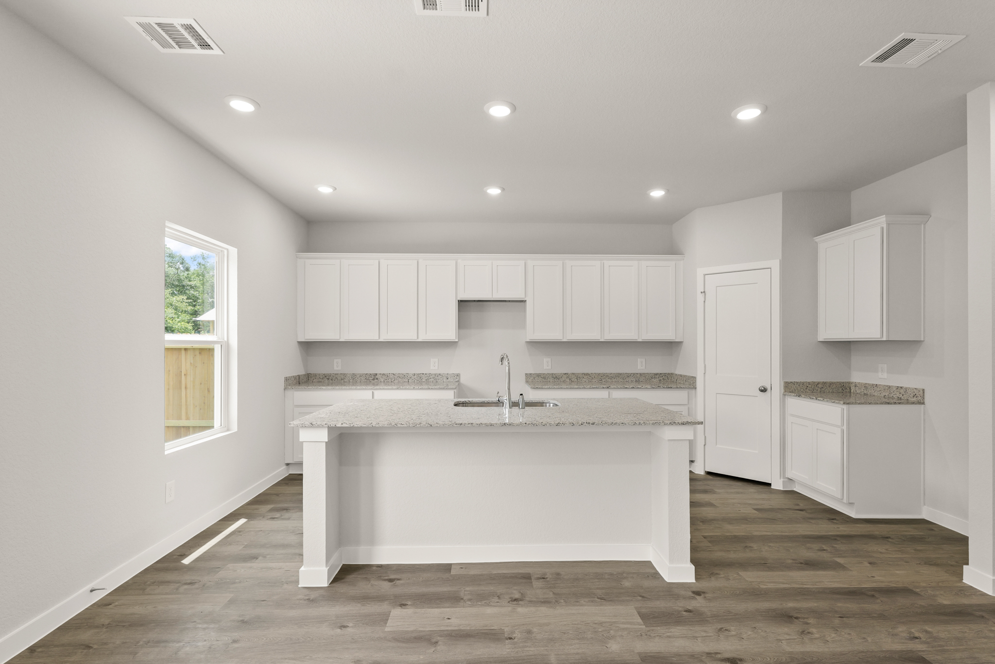 A kitchen with white cabinets.