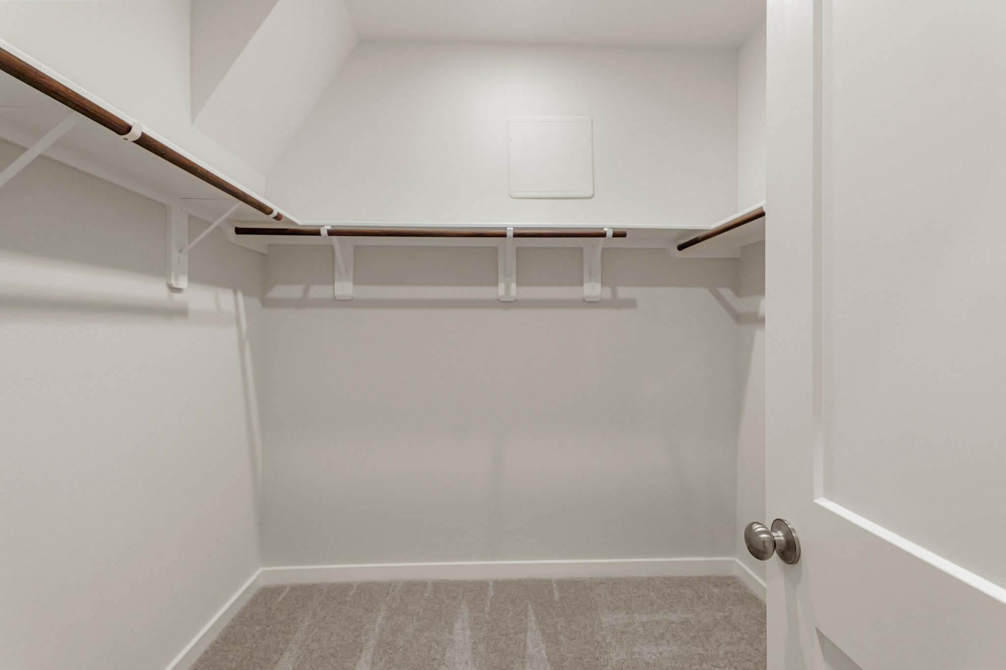 A white room with a white door and a metal railing.