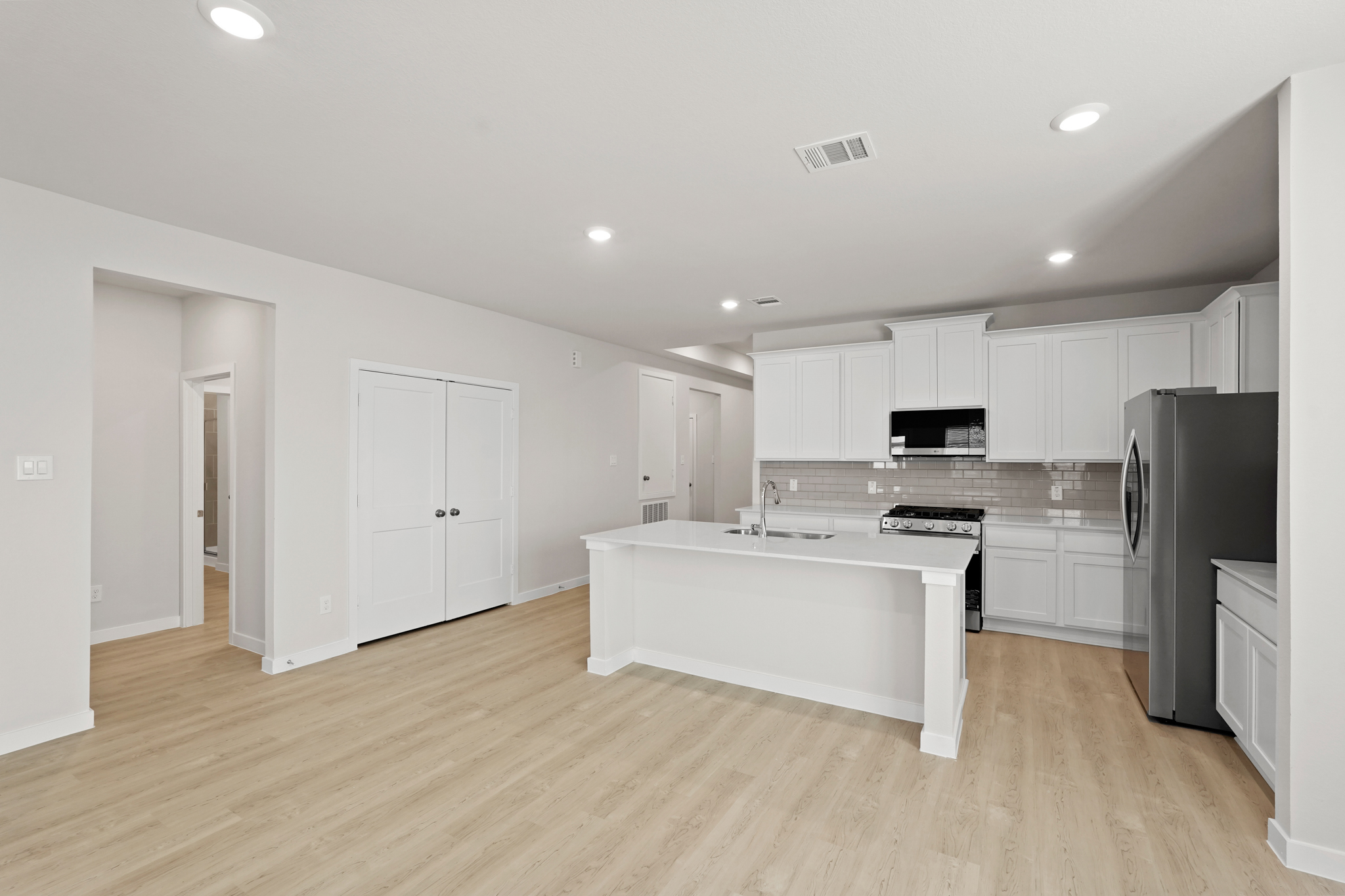 A kitchen with white cabinets.