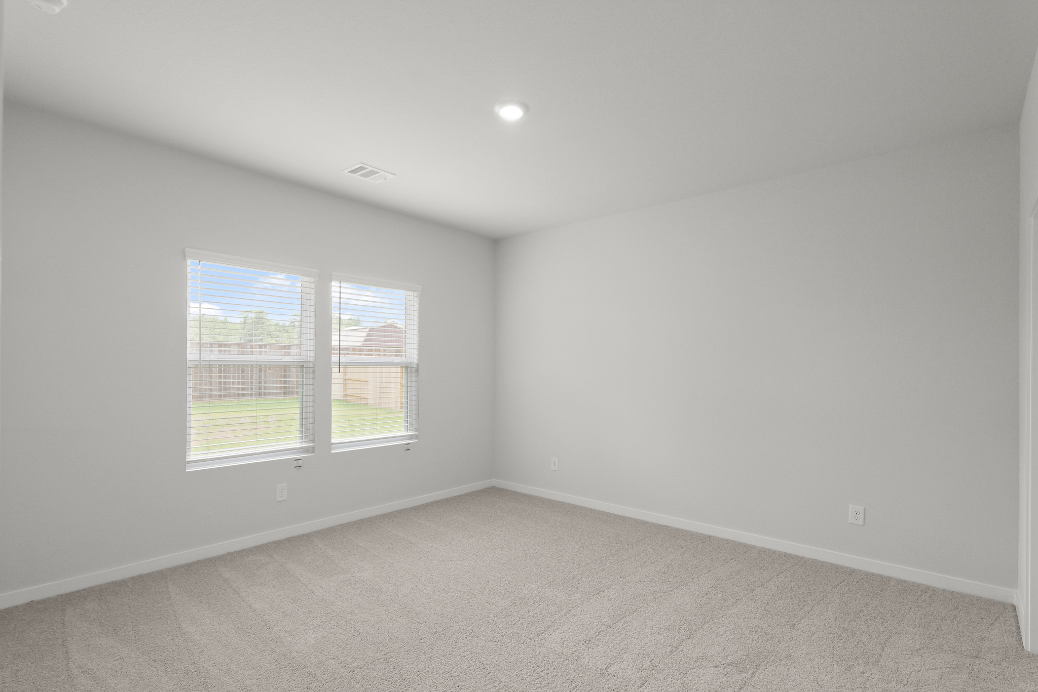 A room with a window and a carpet.