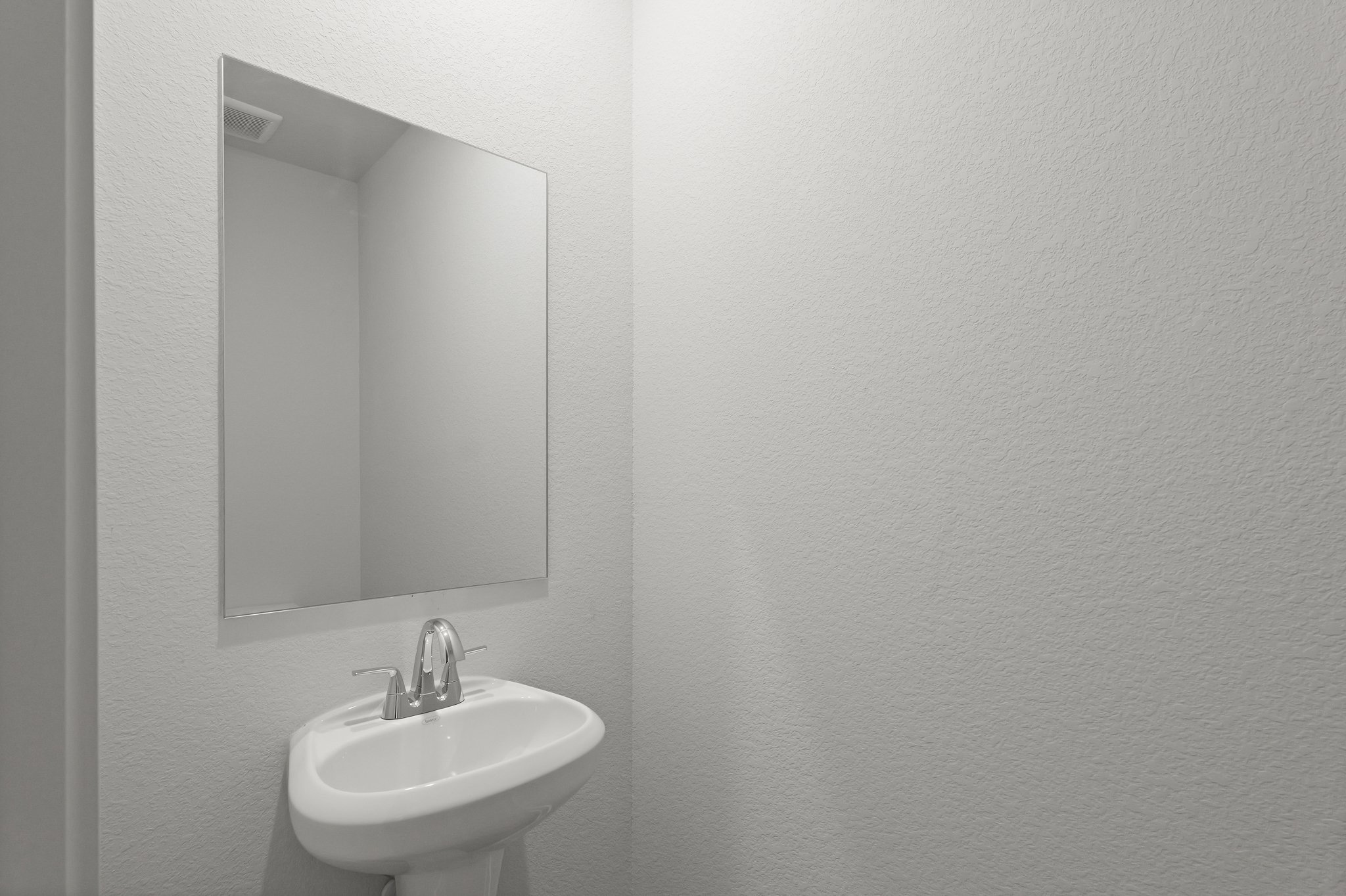 A bathroom with a round mirror.