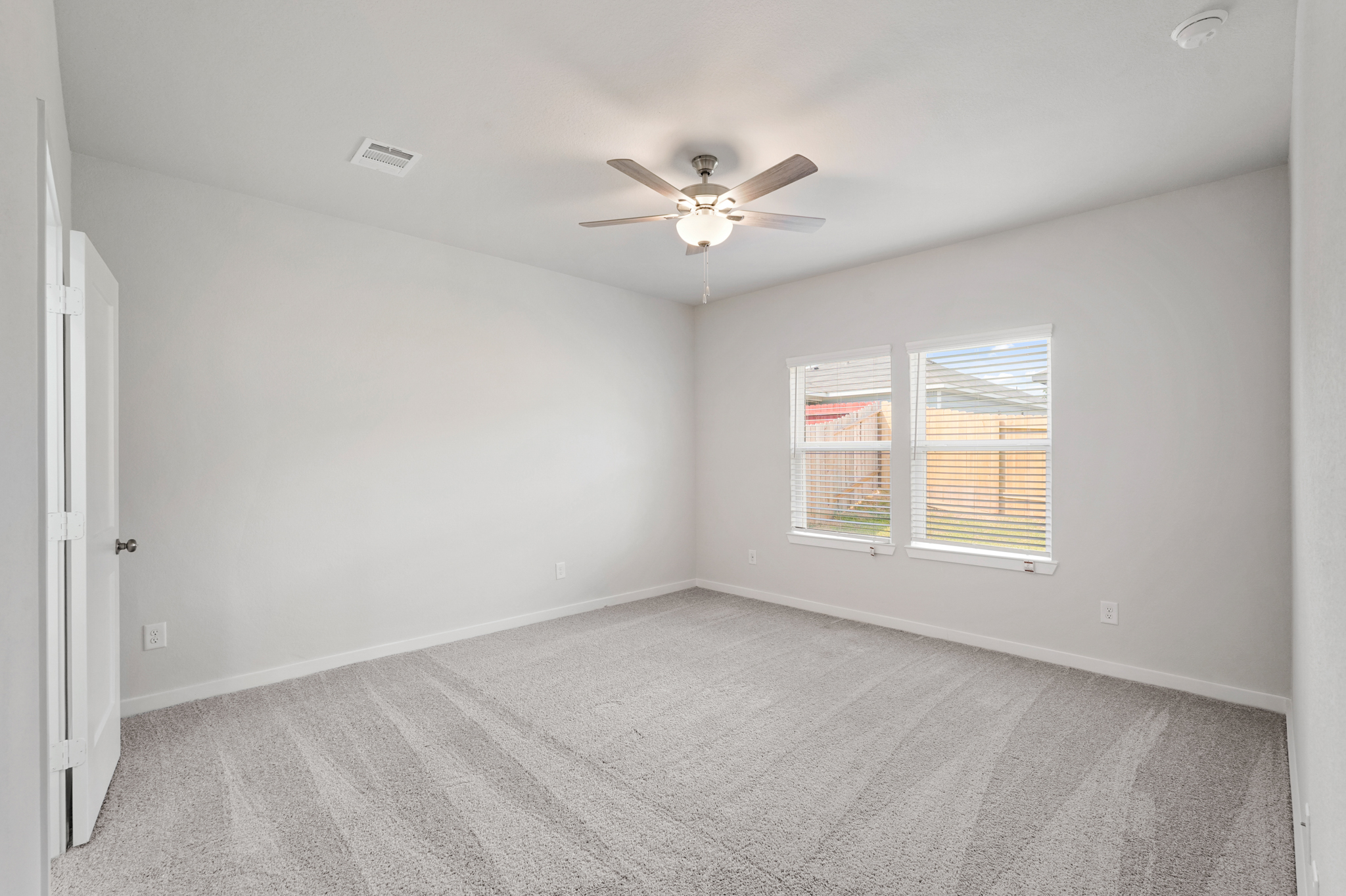 A room with a ceiling fan and a window.