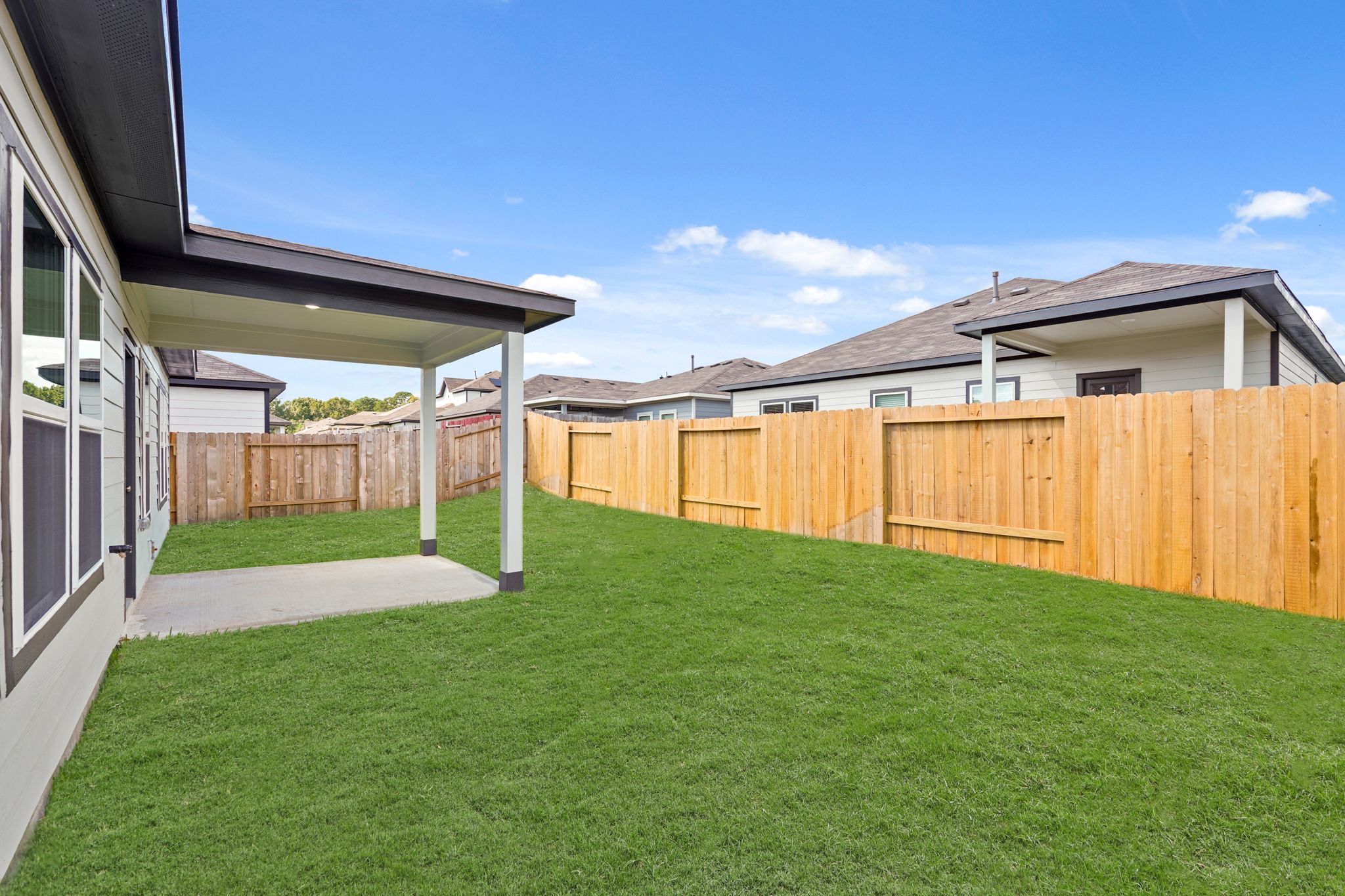 A fenced in yard with a house in the background.