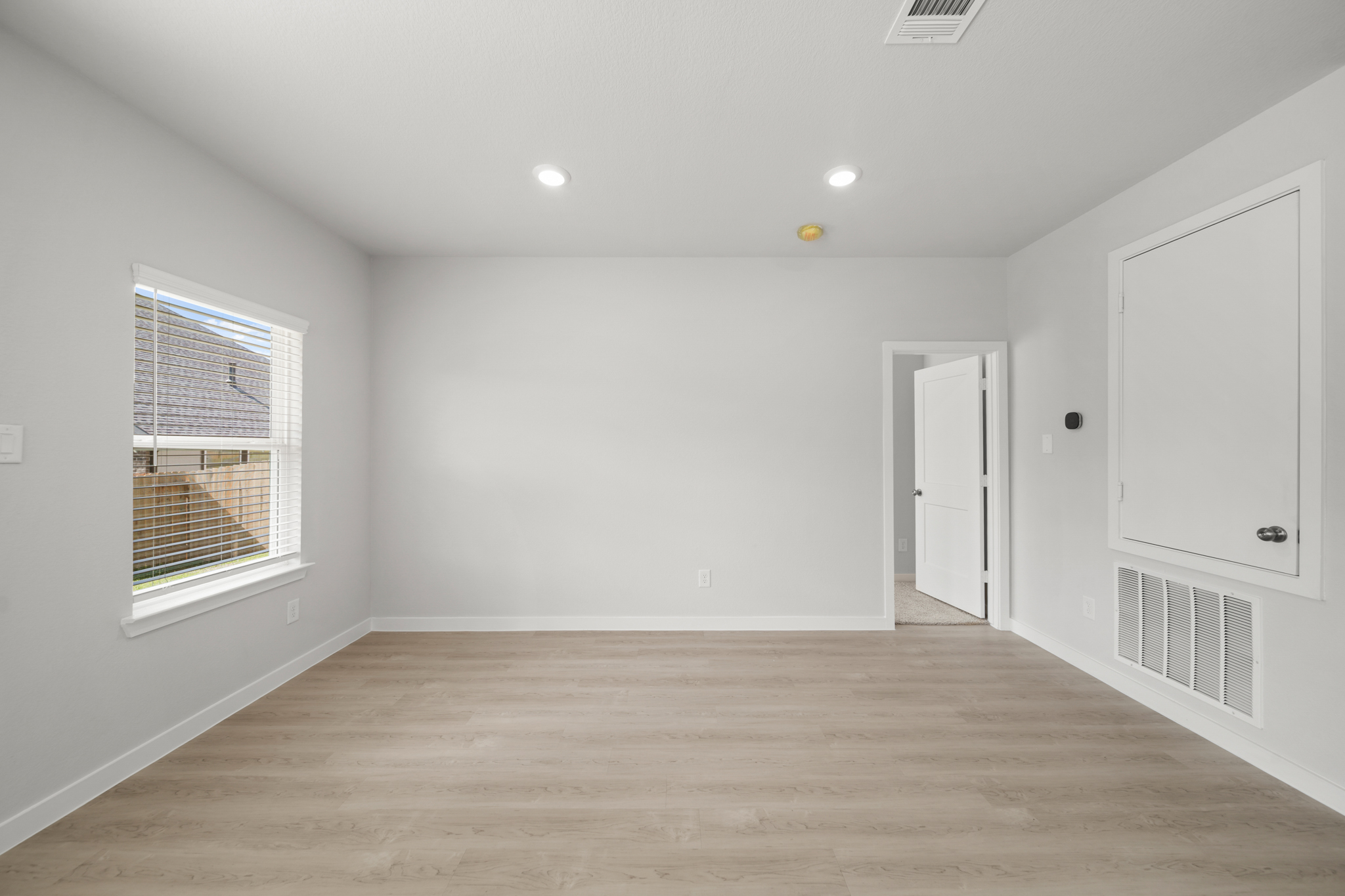 A room with white walls and a wood floor.