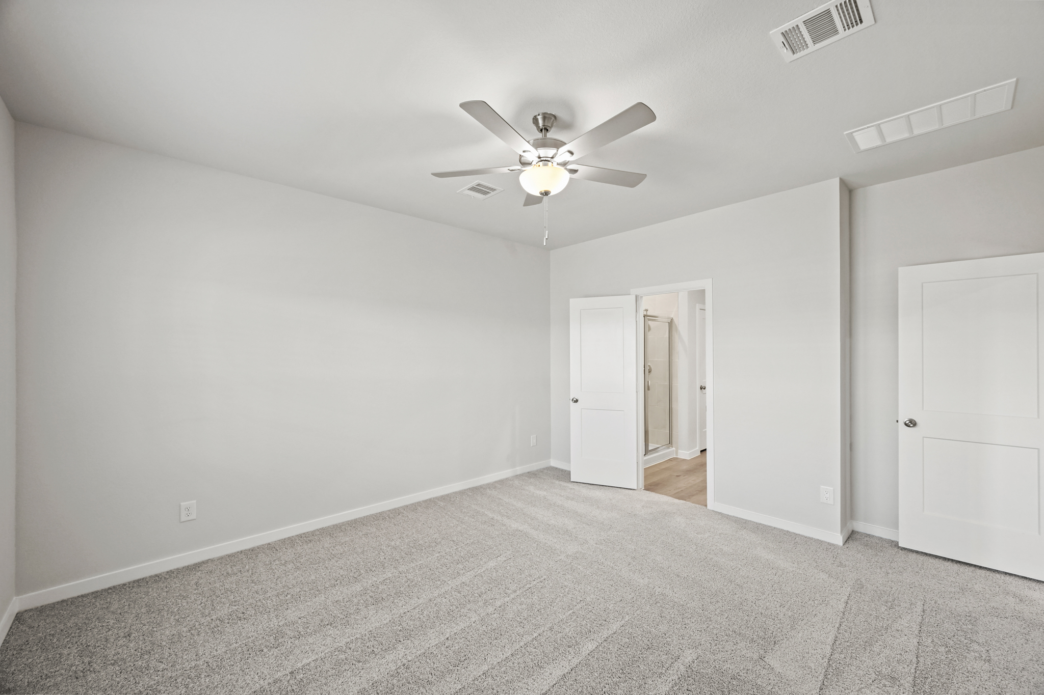 A room with a ceiling fan and a door.