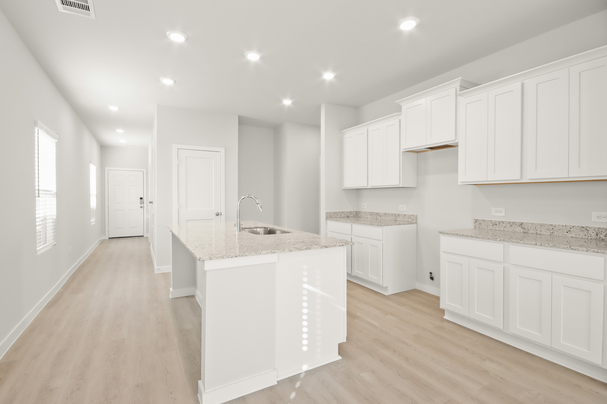 A kitchen with white cabinets.