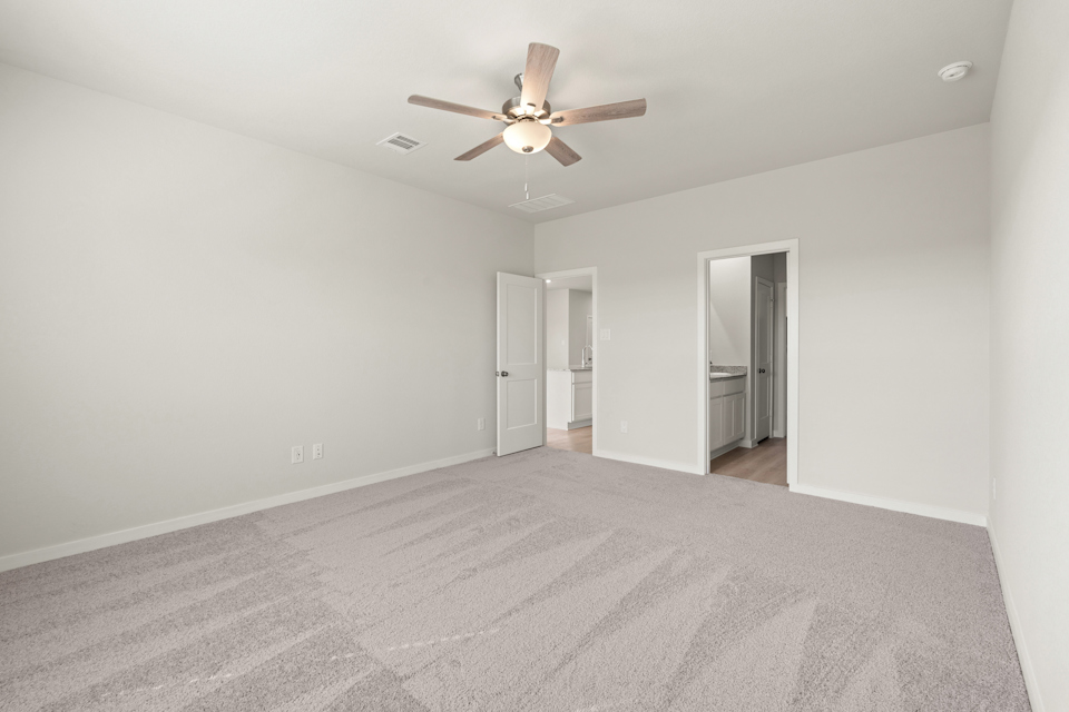 A room with a ceiling fan and a door.