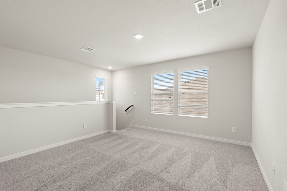 A room with a carpet and windows.
