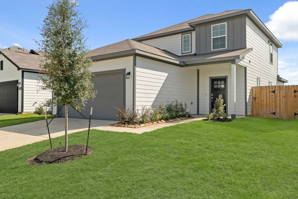 A house with a tree in the front yard.