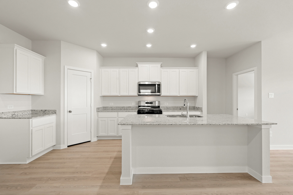 A kitchen with white cabinets.
