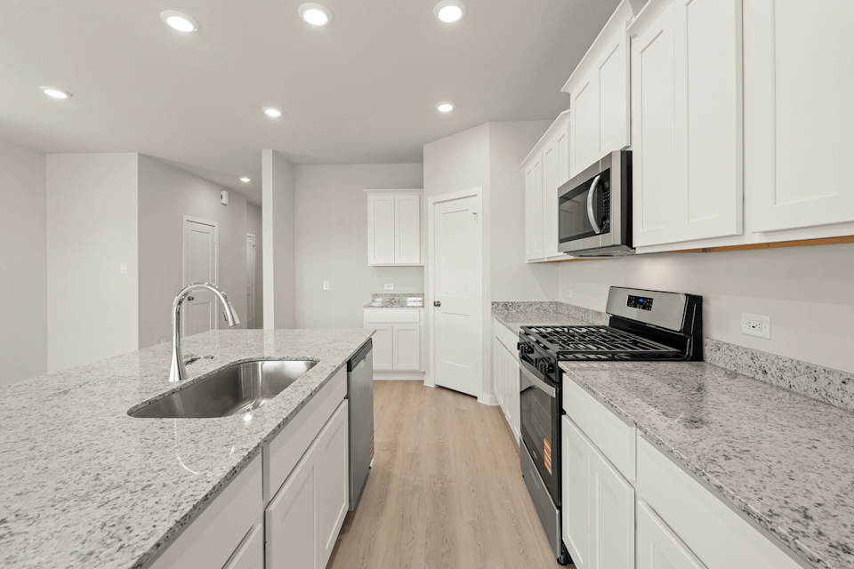 A kitchen with white cabinets.