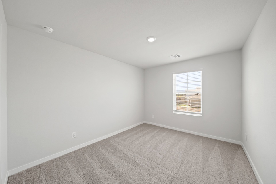 A room with a carpet and a window.