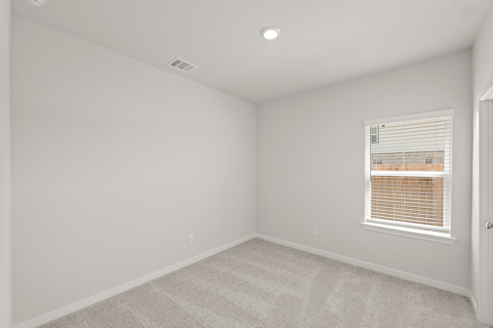 A room with a window and a carpet.