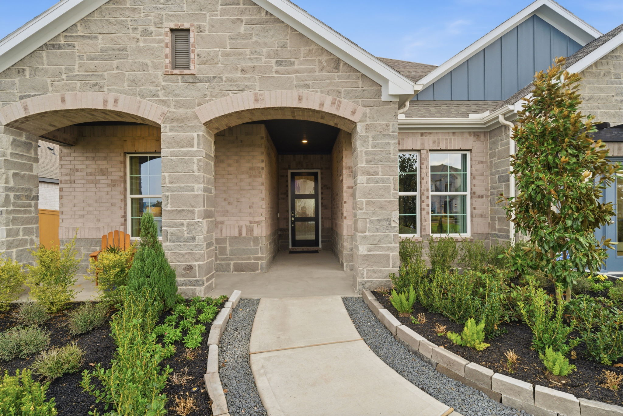 A building with a walkway and plants.