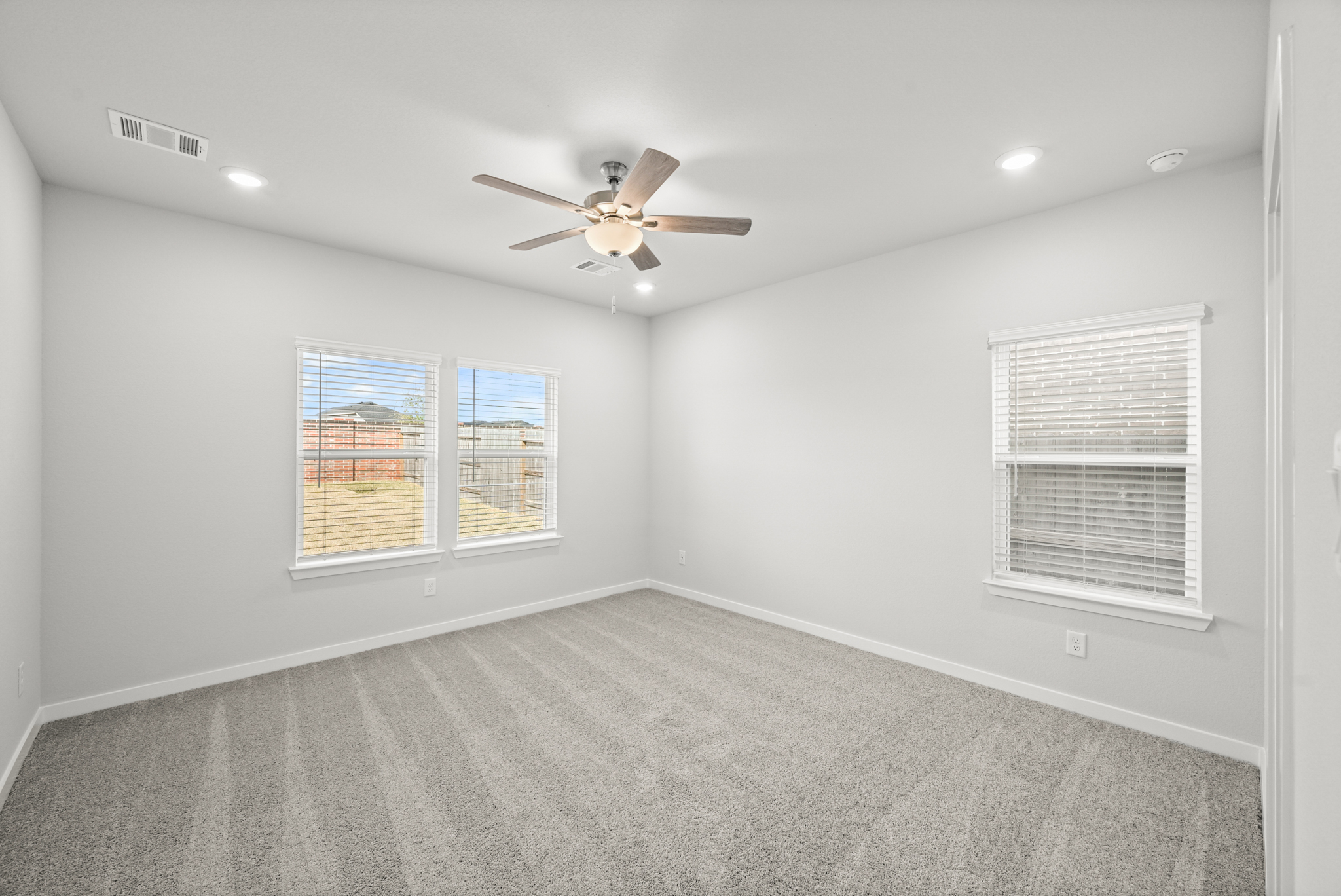 A room with a ceiling fan and a window.
